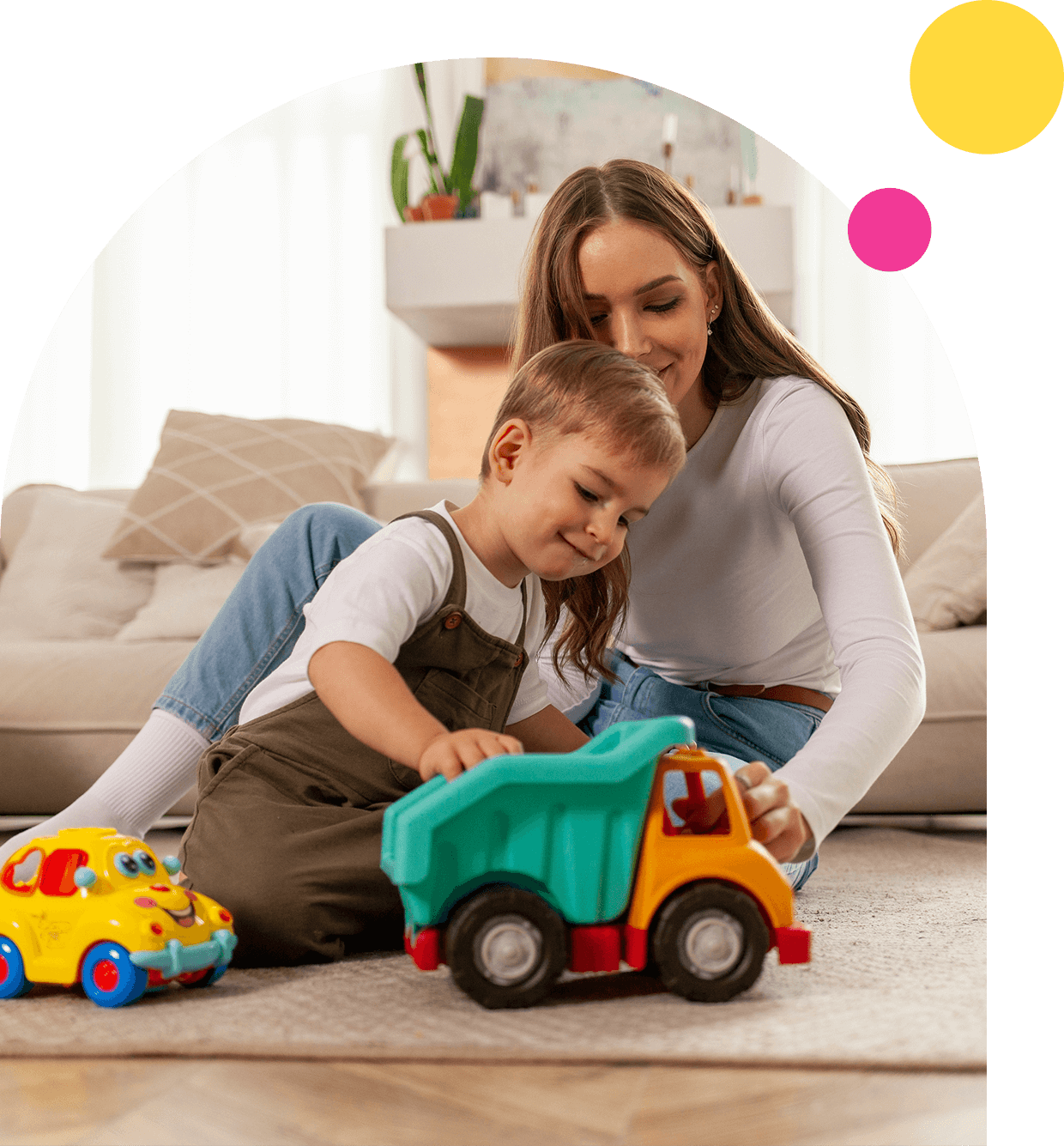 Mother and child playing with toy trucks.
